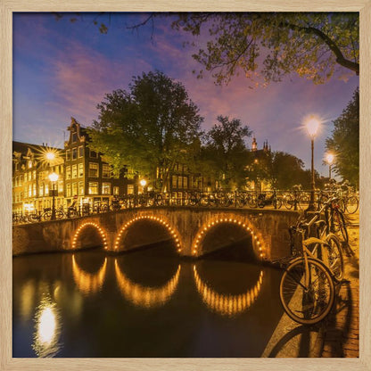 An idyllic nightscape view of Keizersgracht canal in Amsterdam, featuring illuminated buildings reflecting on the water under a dark sky. Wall Art