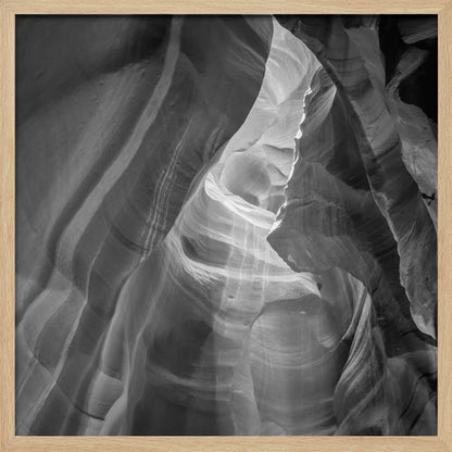 Black and white photo of light in a narrow slot canyon, highlighting smooth, layered rock formations. Nature wall art.