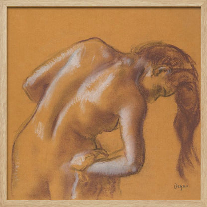 A framed pastel sketch by Edgar Degas titled 'After the Bath, Woman Drying Herself'. The artwork depicts a nude woman from the back, bending forward as if drying herself. The drawing is on a warm ochre-colored paper, with her form defined by brown lines and white highlights, especially along her spine and shoulders. Her long brown hair cascades down on the right side. Wall Art