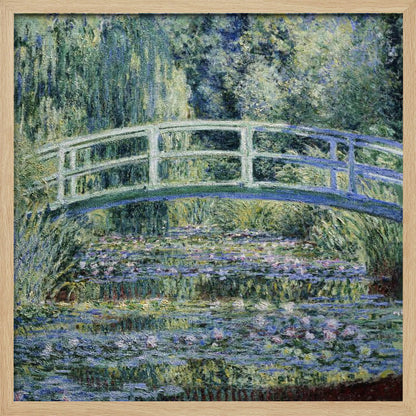 An Impressionist painting by Claude Monet, 'The Water Lily Pond', in a light wood frame. A pale green Japanese footbridge arches over a tranquil pond filled with pink and white water lilies, reflecting the lush green and blue foliage of weeping willows that surround it. Poster