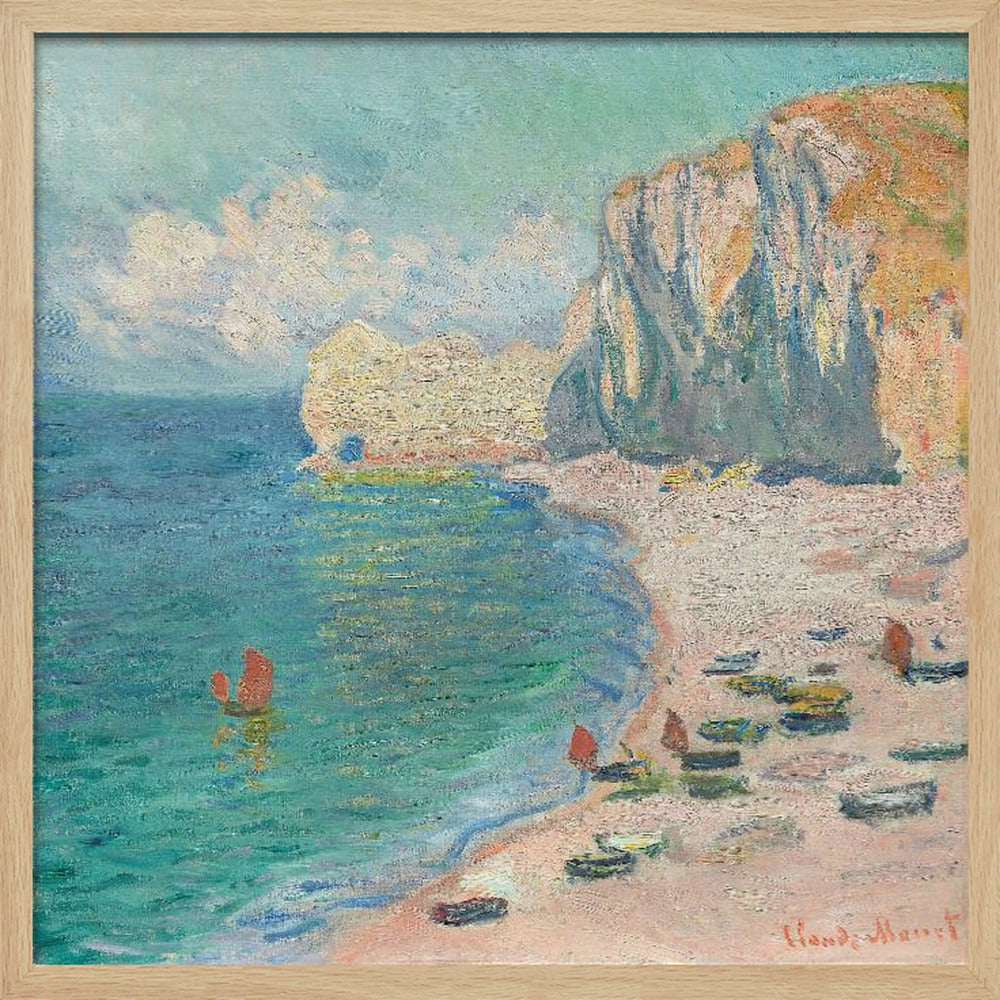 An impressionist painting by Claude Monet depicting the beach at Étretat, France, enclosed in a light wood frame. The artwork shows tall, light-colored cliffs on the right, a sandy beach with small boats, and vibrant turquoise water with a few red-sailed boats. The sky is partly cloudy. Decor