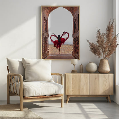 A woman in a flowing red dress dances joyfully, framed by an ornate, carved archway. Seen from behind, she leaps with her arms outstretched, holding a long red scarf that forms a heart shape around her against a bright, hazy sky. Poster
