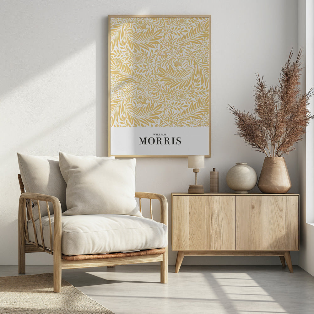 A framed exhibition-style poster of a William Morris design. The poster features an intricate, golden-yellow floral and leaf pattern on a white background. Below the pattern, the name 'WILLIAM MORRIS' is printed in black text. The entire artwork is presented in a simple black frame. Wall Art