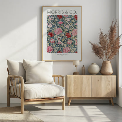 A framed art print of William Morris's 'Cray' pattern, featuring a dense floral design with large pink and red stylized flowers and foliage on a dark navy blue background. The text 'MORRIS & CO.' is above the pattern, and '- WILLIAM MORRIS - CRAY' is below. Artwork