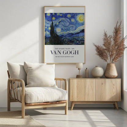 A framed art print of Vincent van Gogh's 'The Starry Night' from 1889. The painting depicts a dramatic, swirling night sky in deep blues and yellows, with a bright crescent moon and glowing stars. A large, dark cypress tree stands in the foreground, reaching towards the sky, with a peaceful village nestled in the hills below. The poster has a white border at the bottom with the text 'THE STARRY NIGHT - 1889', 'VAN GOGH', and 'MUSEUM OF MODERN ART'. Wall Art