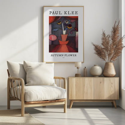 A poster of Paul Klee's 1922 painting 'Autumn Flower'. The abstract artwork features a stylized vase with surreal flowers in shades of red, orange, blue, and purple. The poster has a white border with 'PAUL KLEE' at the top and 'AUTUMN FLOWER 1922' at the bottom, all within a thin black frame. Poster