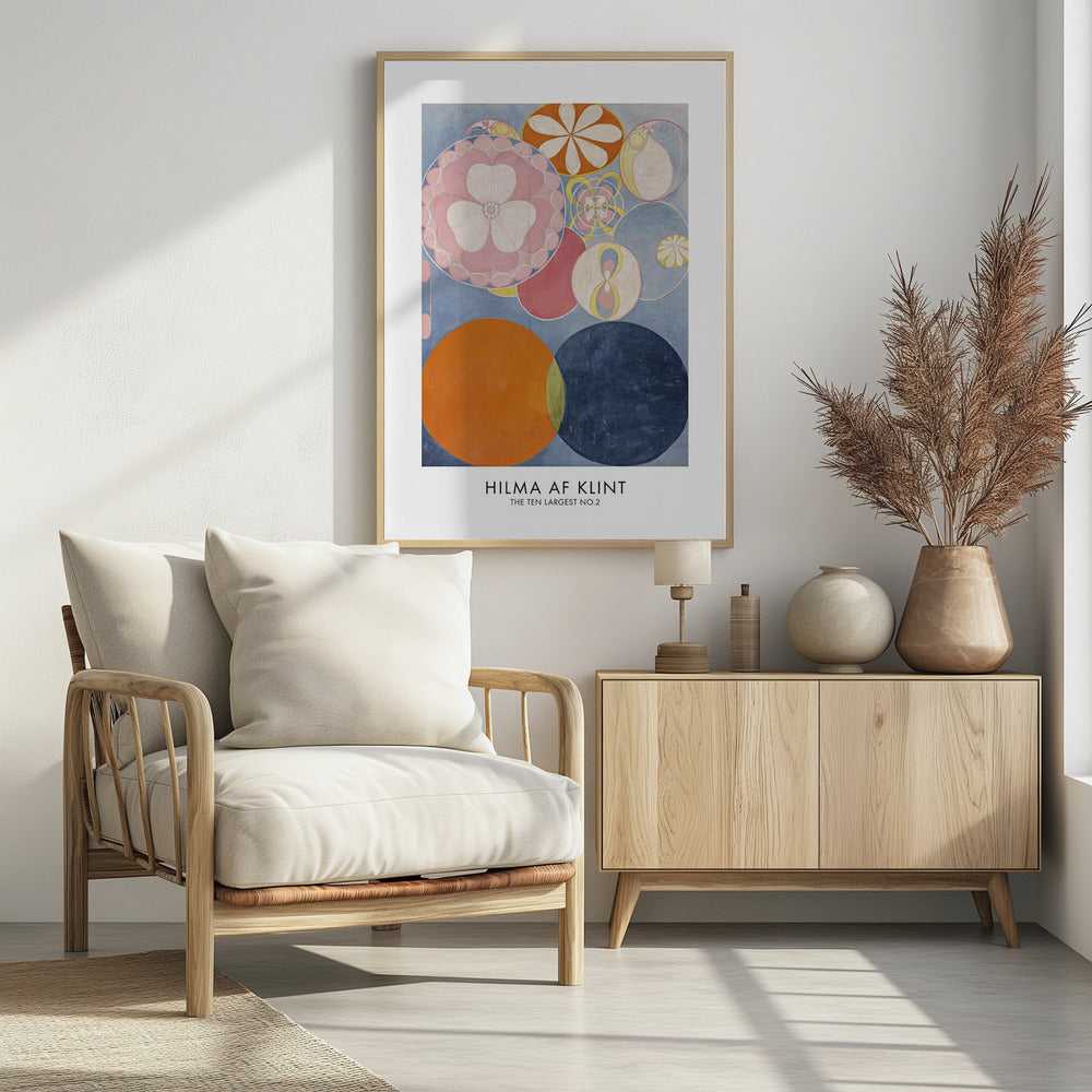 A poster of Hilma af Klint's abstract painting 'The Ten Largest, No. 2'. The artwork features a variety of colorful circles and floral-like motifs on a light blue background, with dominant colors of pink, orange, and dark blue. The artist's name and artwork title are printed below. Artwork