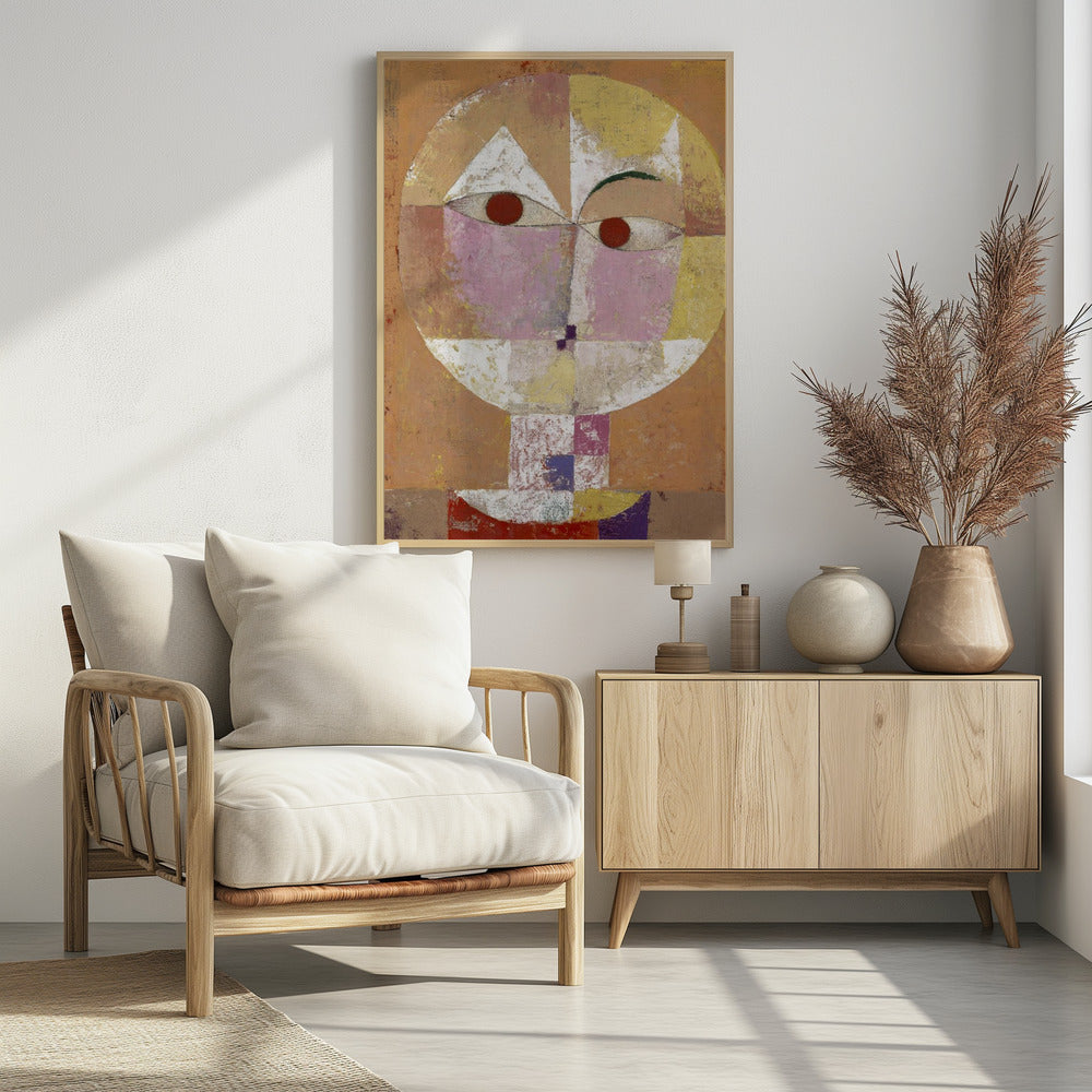 An abstract portrait painting of a stylized head, often identified as Paul Klee's 'Senecio'. The face is composed of geometric blocks of color, including pink, yellow, and white, with two prominent red circles for eyes, all set against a textured, earthy orange and brown background within a black frame. Print