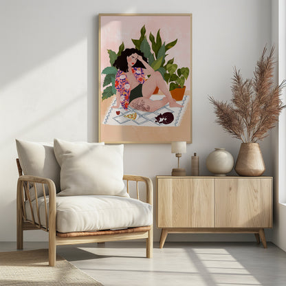 An illustration of a woman with dark curly hair relaxing on a patterned blanket indoors. She is wearing a green swimsuit and a pink floral shirt, with a prominent snake tattoo on her thigh. Next to her is a slice of pizza, a glass of red wine, and a sleeping black and white cat, all set against a backdrop of large green houseplants and a pink wall. Artwork