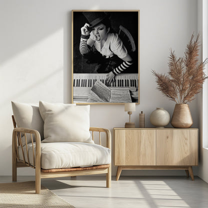 A dramatic black and white high-angle photograph of a woman in a top hat and striped arm warmers, shouting or singing passionately while seated at a piano with sheet music. Print