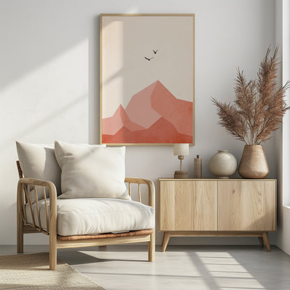 A minimalist framed artwork featuring geometric, faceted mountains in shades of pink and coral against a light cream sky. Two small black birds are shown flying above the peaks, creating a serene and modern nature scene. Wall Art