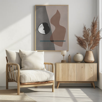 A modern abstract artwork in a black frame, featuring a composition of layered shapes in muted tones. The background is split between gray and pale pink, with a black and white circular element showing a face profile, a large translucent brown organic shape, and a horizontal teal line. Decor