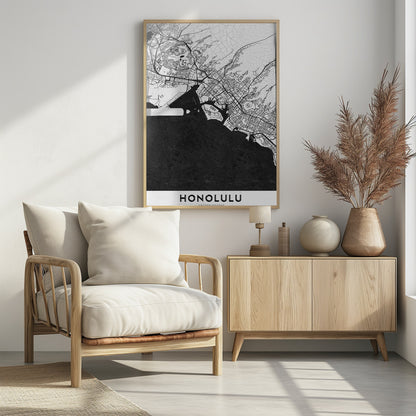 A framed, minimalist black and white map of Honolulu, Hawaii. The city's streets and coastline are rendered in black lines on a white background, while the ocean is a solid, textured black. The word 'HONOLULU' is printed in black sans-serif font at the bottom. Artwork