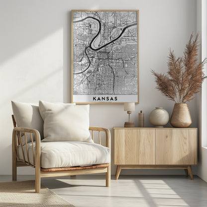 A modern, black and white line-art map of Kansas City, displayed in a black frame. The map details the intricate grid of streets and the winding path of a major river. At the bottom, a white border contains the word 'KANSAS' in bold, black capital letters. Artwork