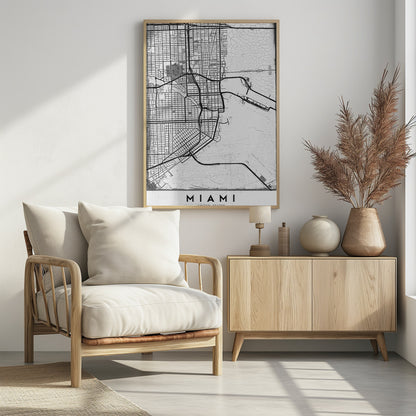 A minimalist black and white street map of Miami, Florida, with a distressed, textured background. The map is framed in black with the word 'MIAMI' printed in bold capital letters at the bottom. Artwork