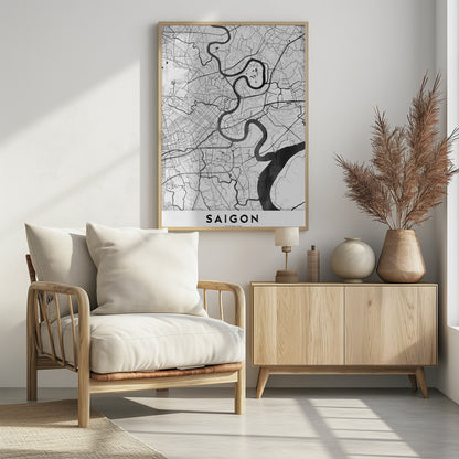 A minimalist black and white map poster of Saigon, Vietnam, displayed in a black frame. The map highlights the winding Saigon River in solid black against a white background with a complex grid of roads and smaller waterways in thin black lines. At the bottom, a white border contains the word 'SAIGON' in bold, black, capital letters. Wall Art