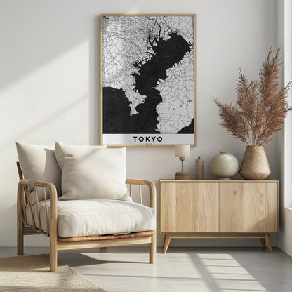 A minimalist black and white map of Tokyo, Japan, in a black frame. The map shows the city's road network in thin black lines on a white background, while Tokyo Bay and other water bodies are depicted in solid black. A white banner at the bottom contains the word 'TOKYO' in a clean, sans-serif font. Wall Art