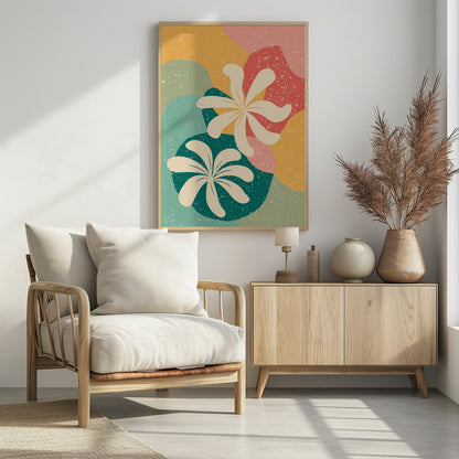 An abstract art print featuring two large, stylized, cream-colored flowers. The background is composed of layered, organic shapes in mustard yellow, teal, coral, and light green, all covered with a white speckled texture, reminiscent of terrazzo. The entire piece is enclosed in a thin black frame. Decor