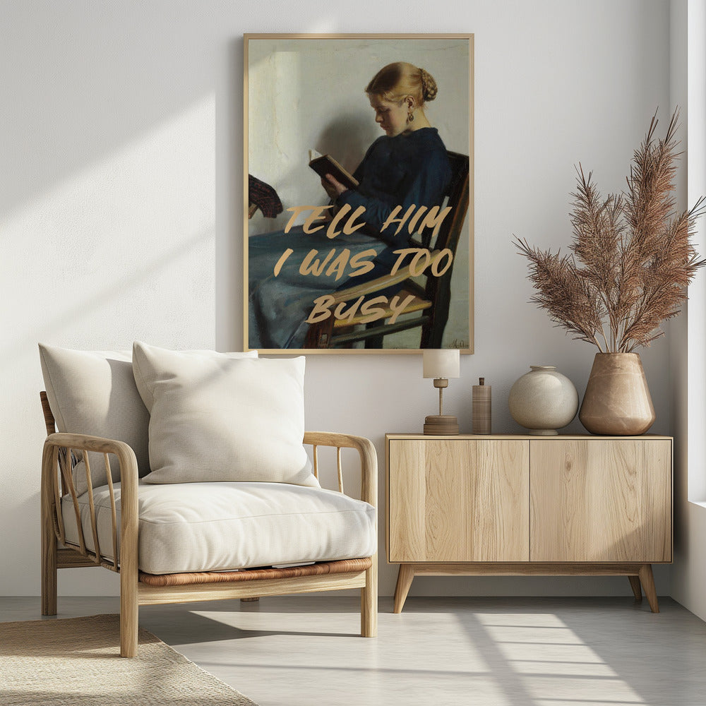 A classical painting of a woman in a blue dress sitting in a wooden chair, engrossed in reading a book. Overlaid in a modern, tan-colored brush script font is the phrase 'TELL HIM I WAS TOO BUSY'. Wall Art