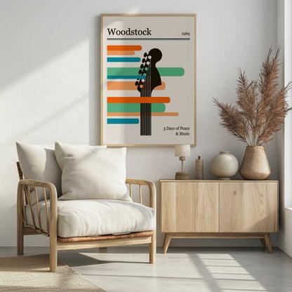 A minimalist retro-style poster for the 1969 Woodstock festival. It features a black silhouette of a guitar neck against horizontal stripes of orange, green, and blue on an off-white background. The text 'Woodstock 1969' is at the top, and '3 Days of Peace & Music' is at the bottom. Artwork