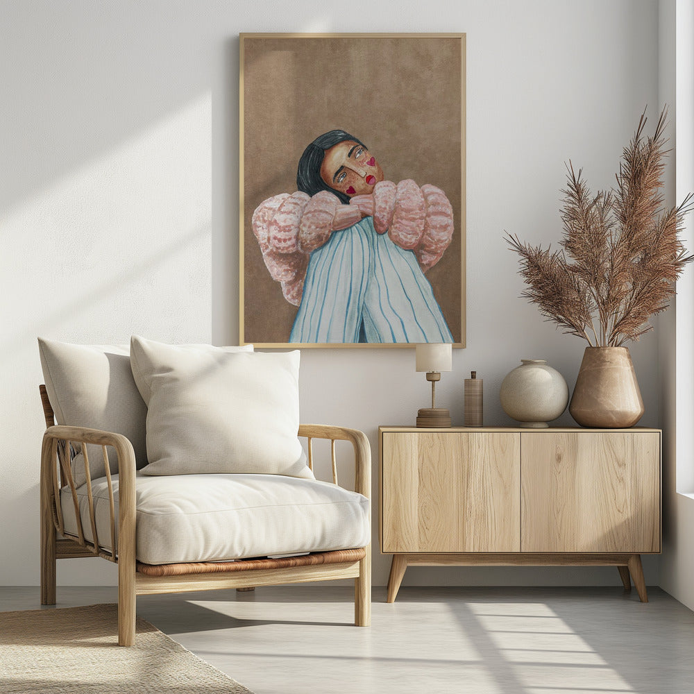An illustrative painting of a person with dark hair, freckles, and red heart stickers on their cheeks. They are wearing a textured pink sweater and light blue pinstripe pants, hugging their knees while looking at the viewer with their head tilted against a solid brown background. Wall Art