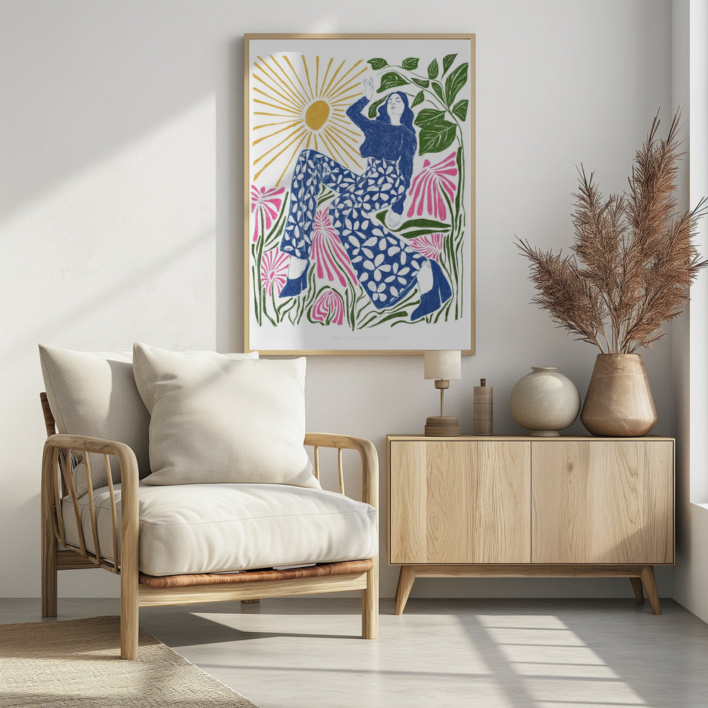 A colorful, stylized illustration of a woman relaxing in a field of large pink flowers under a bright yellow sun. She wears a blue top and blue and white floral pants, with her arm raised lazily. The artwork has a folk art, block-print style. Poster