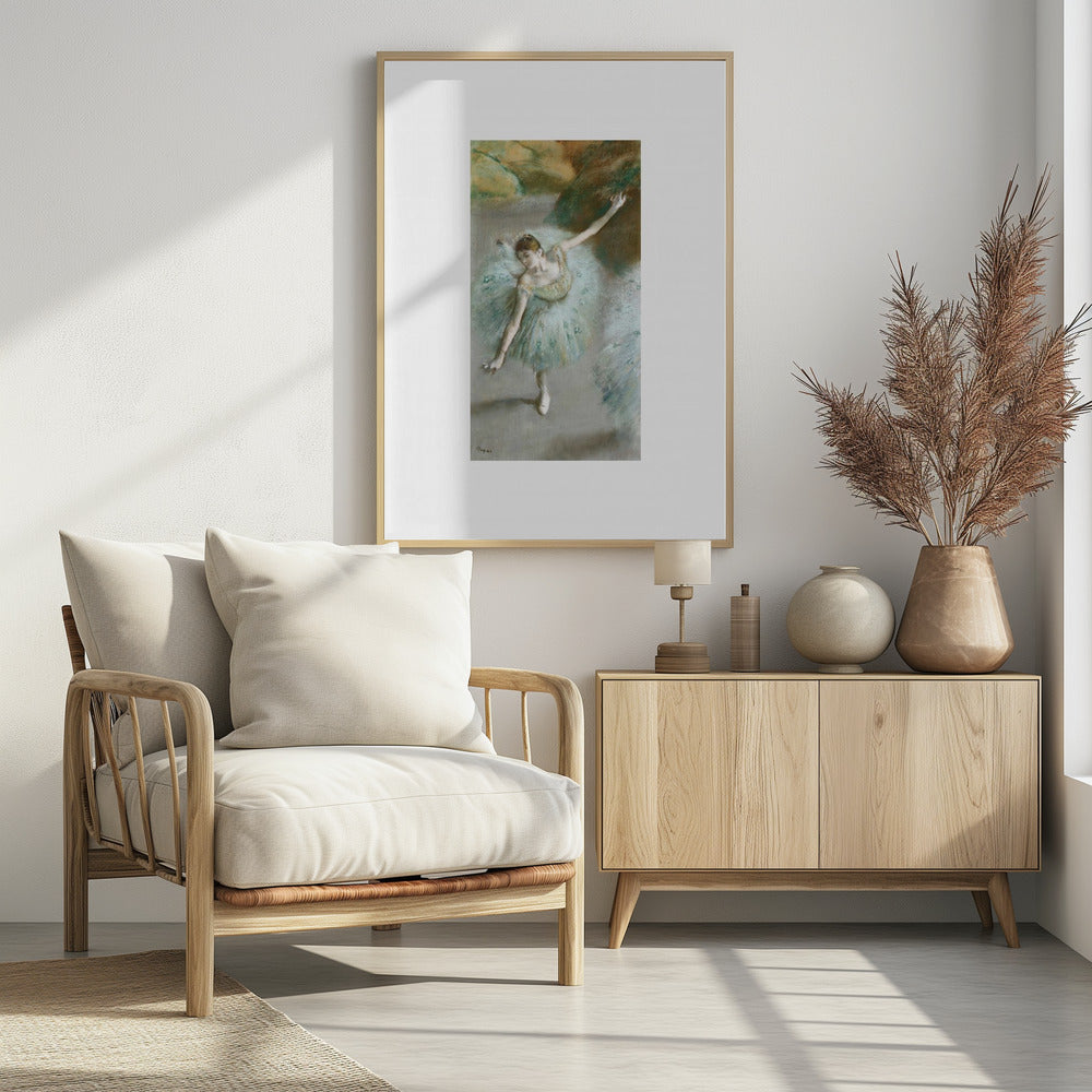 A framed vertical reproduction of an Edgar Degas painting showing a ballerina from a high angle. She wears a voluminous light blue tutu and is posed gracefully with arms outstretched against a soft, impressionistic background of earthy browns and tans. Poster