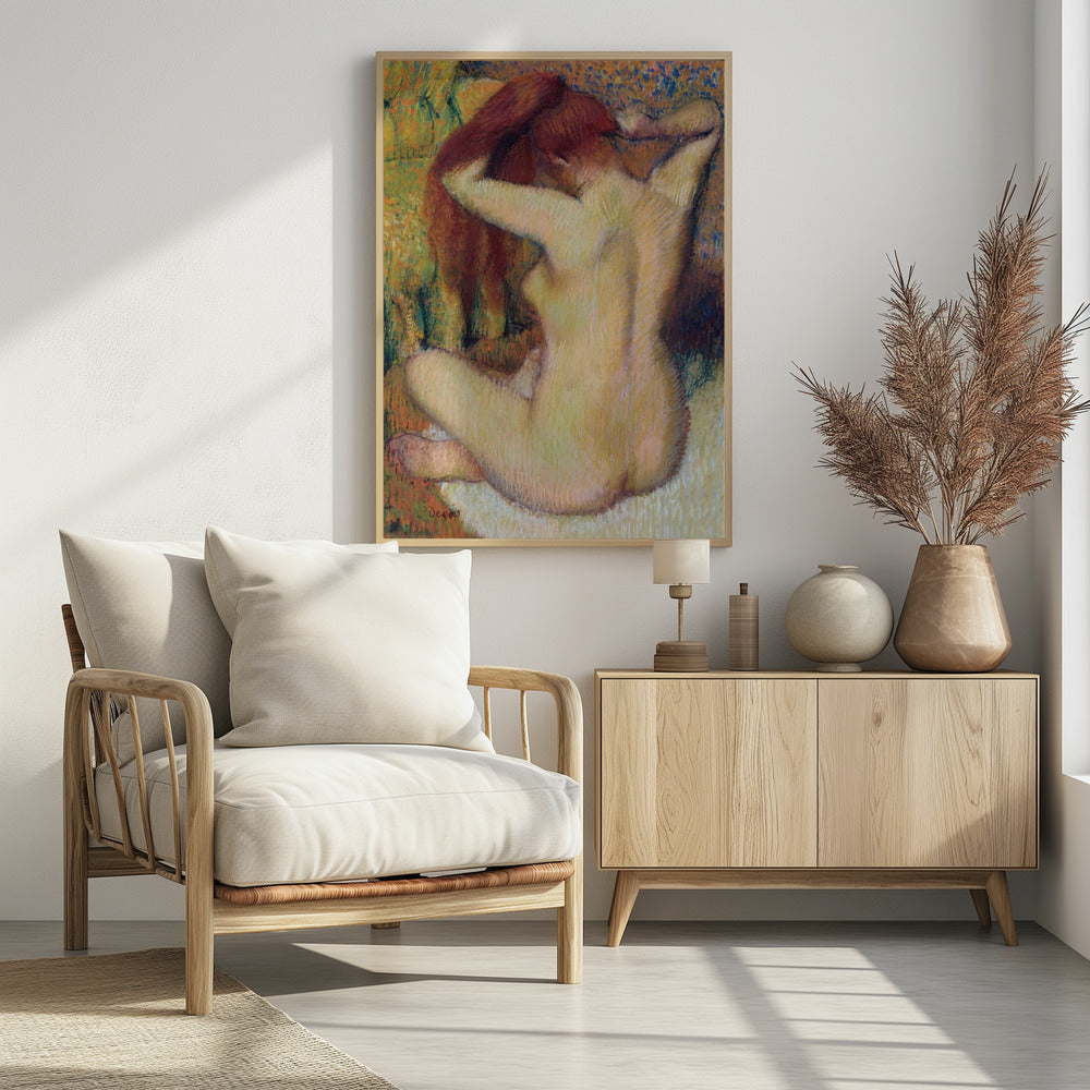 An impressionist pastel painting by Edgar Degas of a nude woman seen from the back. She is sitting on a light-colored surface, gathering her long, auburn hair with both hands behind her head. The background is a textured blend of green, yellow, and blue colors. Poster