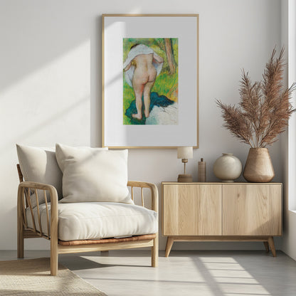 A framed pastel artwork by Edgar Degas showing the back of a nude woman as she dries herself with a white towel in a lush green landscape. The impressionist style is evident in the soft, textured application of color. Artwork