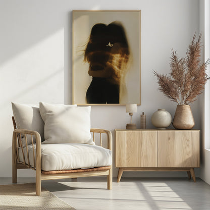 An artistic, long-exposure photograph of two silhouetted figures embracing. Their forms are blurred with motion, and streaks of warm, golden light wash over them against a soft, off-white background, creating a dreamy and intimate mood. Decor