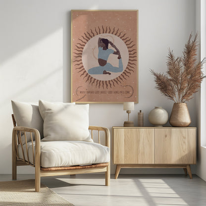 An illustration of a woman in a light blue outfit holding a King Pigeon yoga pose. She is centered within a large, pale circle representing the sun, which has wavy brown rays. The background is a dusty rose color with white specks, and a quote at the bottom reads, 'When I radiate good energy, good things will come.' Decor