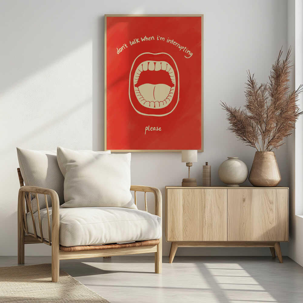 A humorous framed poster with a red background featuring a cream-colored line drawing of a large, open mouth. Above the mouth, the text reads 'don't talk when i'm interrupting' in an arch, and below it says 'please'. Print