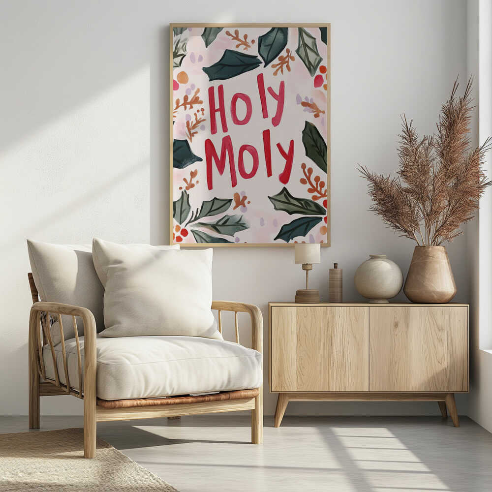 A watercolor-style Christmas-themed artwork with the phrase 'Holy Moly' hand-painted in bold red letters in the center. The text is framed by a loose arrangement of dark green holly leaves, red and orange berries, and small brown sprigs against a light cream and pink background. The artwork is shown in a thin black frame. Artwork