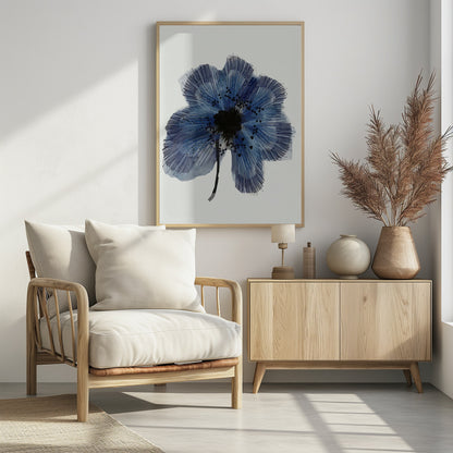 A framed modern illustration of a single large blue flower on a white background. The flower's petals are rendered with a combination of light blue watercolor wash and fine, radiating dark blue lines, creating a sense of texture. The center of the flower is a solid black mass, with smaller black shapes scattered across the petals, and it has a thin black stem. Wall Art