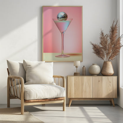 A sleek martini glass filled with an iridescent pink and blue cocktail is centered against a solid pink background. A small, shiny silver disco ball rests on the rim of the glass, completing the festive and stylish composition. Decor