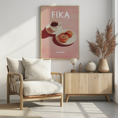 A poster with a pink background featuring the word 'FIKA' in white at the top. Below the text is a cup of black coffee and two cinnamon buns on white plates, with strong shadows. At the bottom, it reads 'MADE IN SWEDEN'. Poster