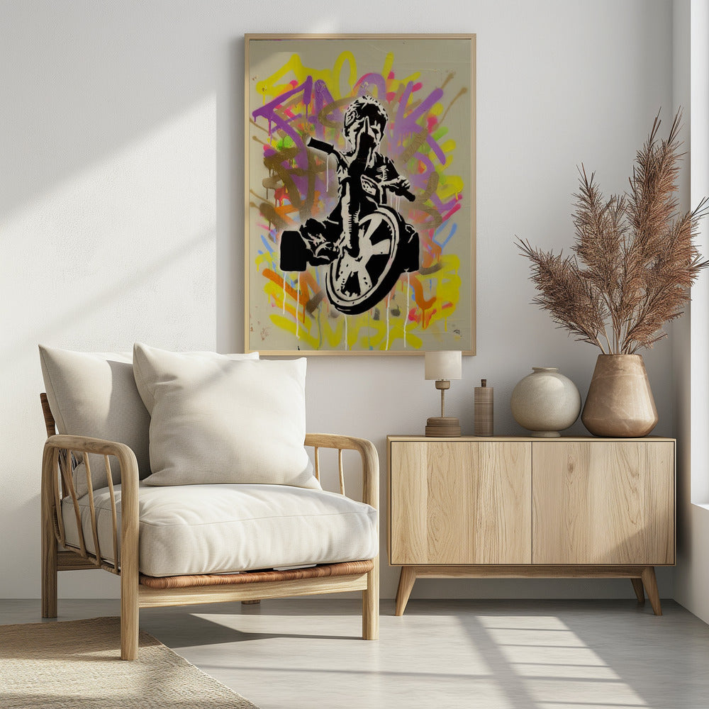A framed street art piece featuring a black and white stencil of a rebellious child on a tricycle giving the middle finger, set against a vibrant, multi-colored graffiti background with paint drips. Artwork