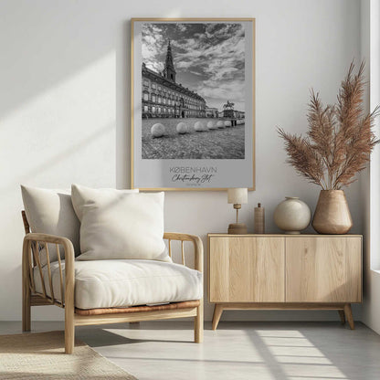 A black and white travel poster of Christiansborg Palace in Copenhagen, Denmark. The image shows the grand building and its tower against a dramatic cloudy sky, with a cobblestone square, stone bollards, and an equestrian statue in the foreground. Text at the bottom identifies the location. Decor