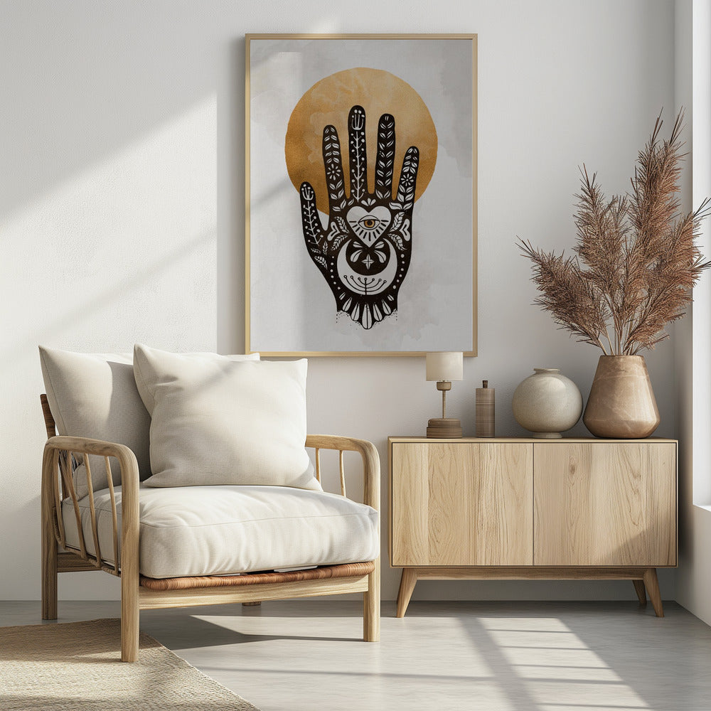 A black-and-white illustration of a hand decorated with intricate folk art symbols, including an eye within a heart on the palm, a crescent moon, and floral motifs on the fingers. A large, textured golden circle, like a sun or moon, serves as the background, set against a light gray, watercolor-style canvas. Decor