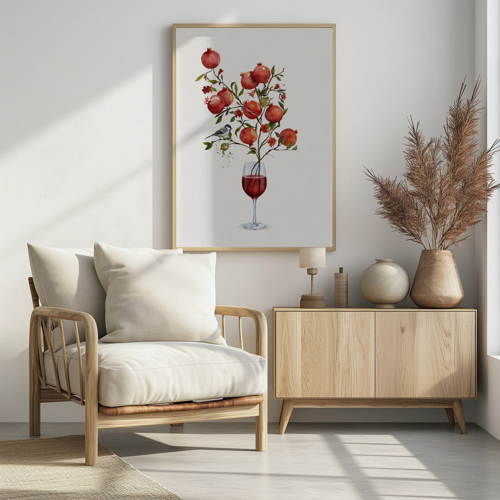 A surreal watercolor painting of a pomegranate branch growing out of a glass of red wine. The branch is laden with ripe red pomegranates, small red blossoms, and green leaves. A small blue and white bird is perched on a twig. The background is a clean, solid white, and the entire image is framed in black. Wall Art