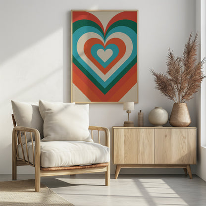 A retro-style graphic art piece featuring a large, centered heart made of concentric layers of orange, green, blue, and cream, creating a hypnotic, repeating pattern. The artwork is presented in a simple black frame. Artwork