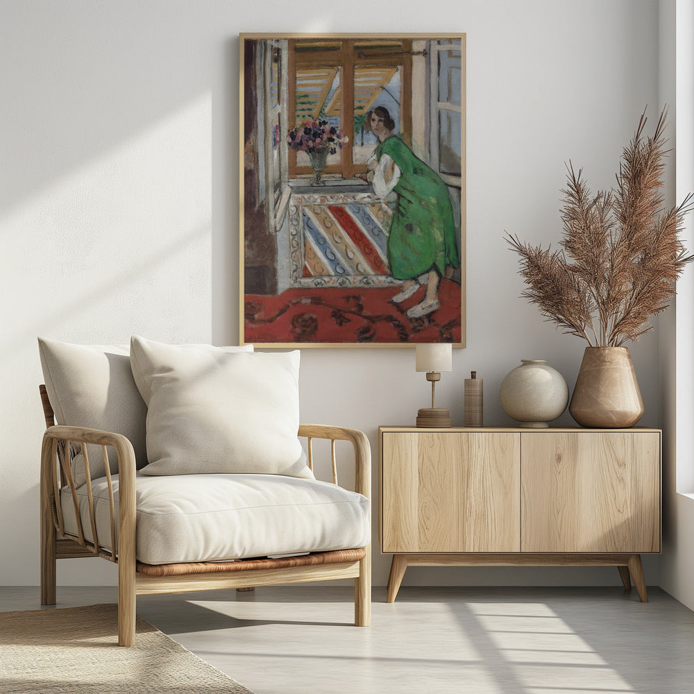 A painting by Henri Matisse depicting a woman in a loose green dress leaning on a windowsill and looking towards the viewer. Outside the open window with tan shutters, a sunny scene with a palm tree is visible. A vase of flowers sits on the sill above a colorful striped panel, and a red patterned rug covers the floor. Print