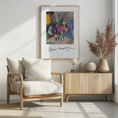 A framed art print of a vibrant Henri Matisse painting. The still life features a bouquet of colorful pink, purple, and white flowers in a blue and white checkered vase, set against a multi-toned background. The artist's signature is displayed below the painting on the white mat. Print