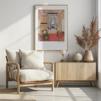 A framed print of a painting by Henri Matisse. The artwork depicts an interior room scene with peach-colored walls, a vibrant pink and red patterned rug, and an armchair. An open window with lace curtains offers a view of the blue sea. Decor
