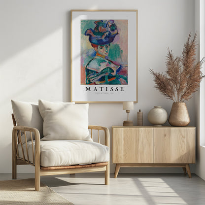 A framed art print of Henri Matisse's famous 1905 Fauvist painting, 'Femme au Chapeau' (Woman with a Hat). The portrait features a woman with an extravagantly decorated, colorful hat, painted with bold, non-naturalistic colors and expressive brushstrokes. Print
