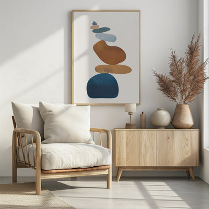 A minimalist abstract painting in a black frame, featuring a precarious stack of colorful, smooth, organic shapes resembling stones against a cream background. The colors range from a large dark blue at the base to brown, ochre, light blue, teal, and pink at the top. Poster