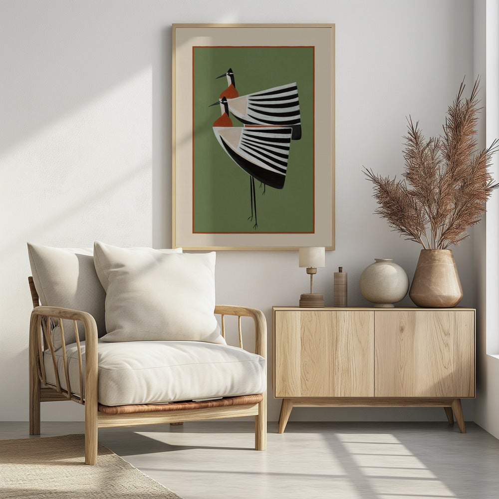 A framed art print featuring two highly stylized birds standing against a solid sage green background. The birds have boat-shaped bodies with bold black and white stripes, orange chests, and long thin black legs and beaks. Wall Art