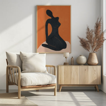 A minimalist abstract art piece featuring a solid black silhouette of a seated female figure against a textured, bold orange background. The figure is posed gracefully, sitting on a light beige, curved surface. The entire piece is enclosed in a simple black frame. Print
