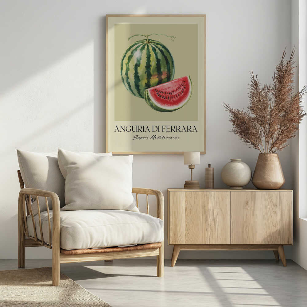 A vintage-style food poster in a black frame, featuring a detailed illustration of a whole striped watermelon and a cut slice showing its red flesh and black seeds. The background is a pale cream-green. Below the fruit, the text reads 'ANGURIA DI FERRARA' and 'Sapori Mediterranei'. Print