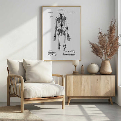 A framed black and white print of a vintage patent illustration for an anatomical skeleton by C.E. Fleck, patented February 7, 1911. The detailed drawing shows a full human skeleton from an anterior view with parts labeled with numbers, set against a light background with official patent text and signatures. Artwork